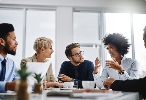 Group of business professionals having an engaging discussion around a conference table in a modern office.