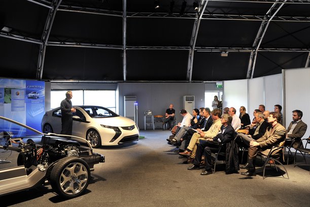 Vehicle and chassis presentation in front of a professional audience in a modern testing environment.