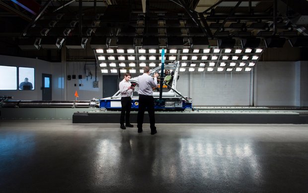 Two people stand in front of a large testing setup featuring numerous lights and cameras, possibly in a laboratory for lighting or imaging tests.