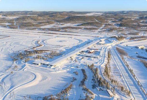 Vue aérienne d'un vaste paysage hivernal enneigé avec plusieurs pistes de conduite et d'essai préparées.